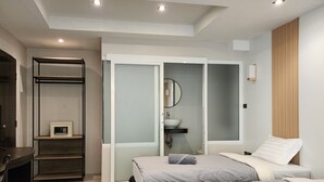 A modern hotel room with two beds, a desk, and a built-in wardrobe. - B & B Patong Beach House (Patong)