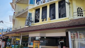 A multi-story building with balconies, air conditioning units, and a sign for a laundry service. - B & B Patong Beach House (Patong)