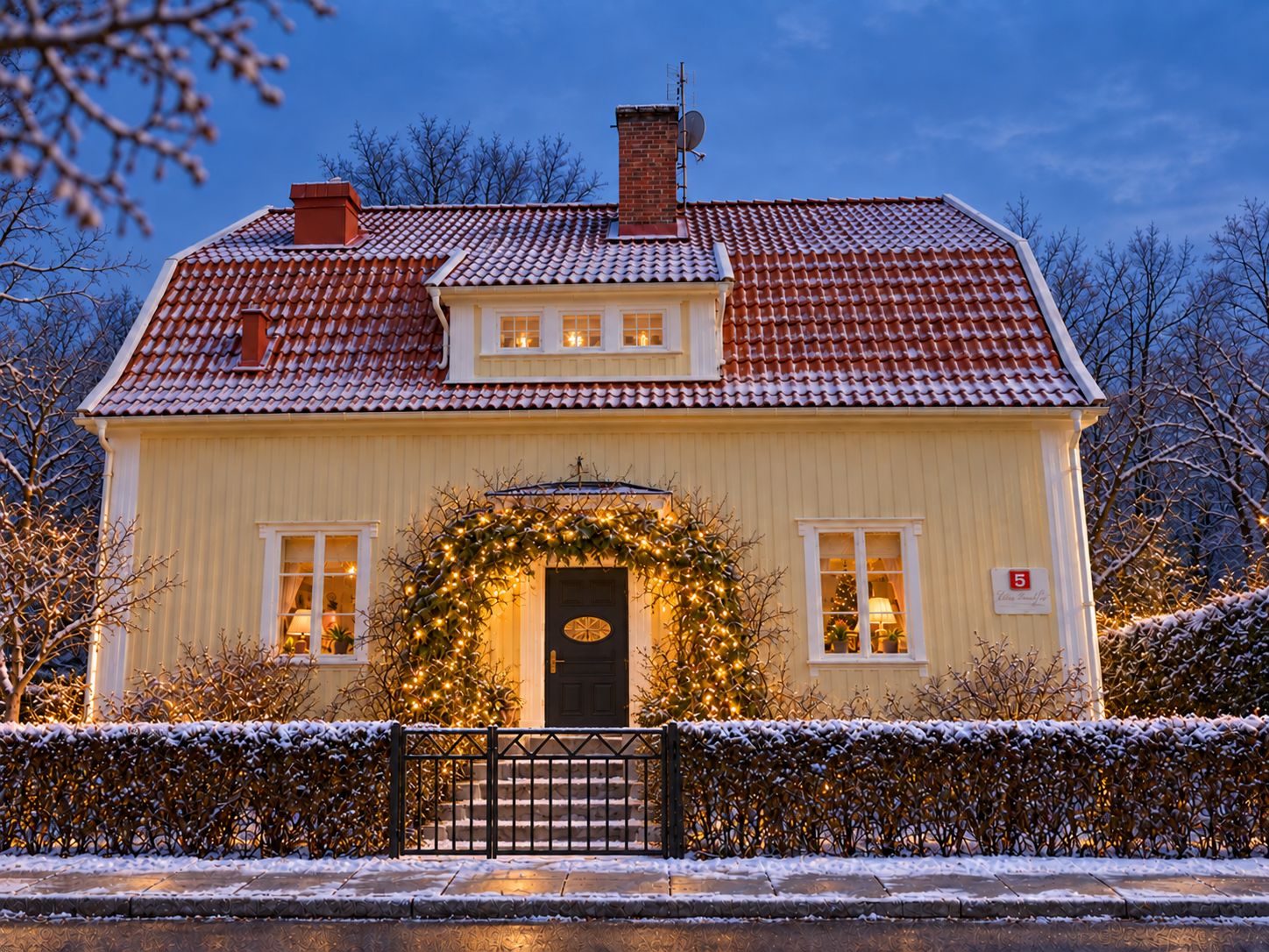 Een tweelaags huis met een rode dakbedekking, een voordeur met een krans en een kleine kerstboom.