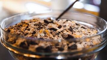 A glass bowl filled with a mix of oats and dried fruits.