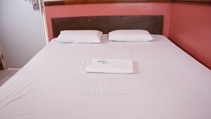 A neatly made bed with white linens and pillows, a folded towel, and a sign indicating the room number and hotel name. - GV Hotel Maasin (Maasin City)