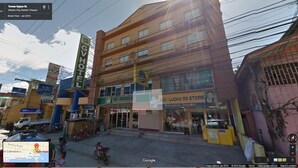 A multi-story building with various businesses including a hotel, a store, and a depôt. - GV Hotel Maasin (Maasin City)