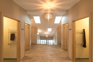 A hallway with wooden flooring, a central chandelier, and skylights. - Guesthouse Garun, Skolavellir (Selfoss)