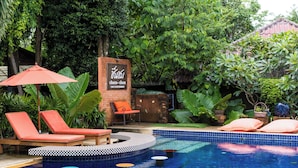 A pool area with lounge chairs, a checkered sun deck, and a sign for 'Chuen Chow Cafe & Restaurant'. - Floraville Phuket Resort (Chalong)
