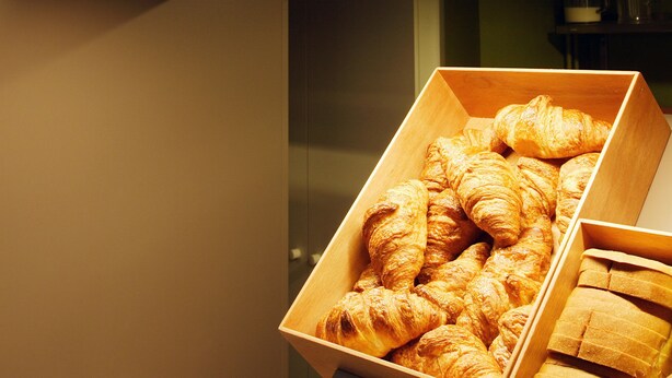 Una vitrina de panadería con cruasanes y pan.