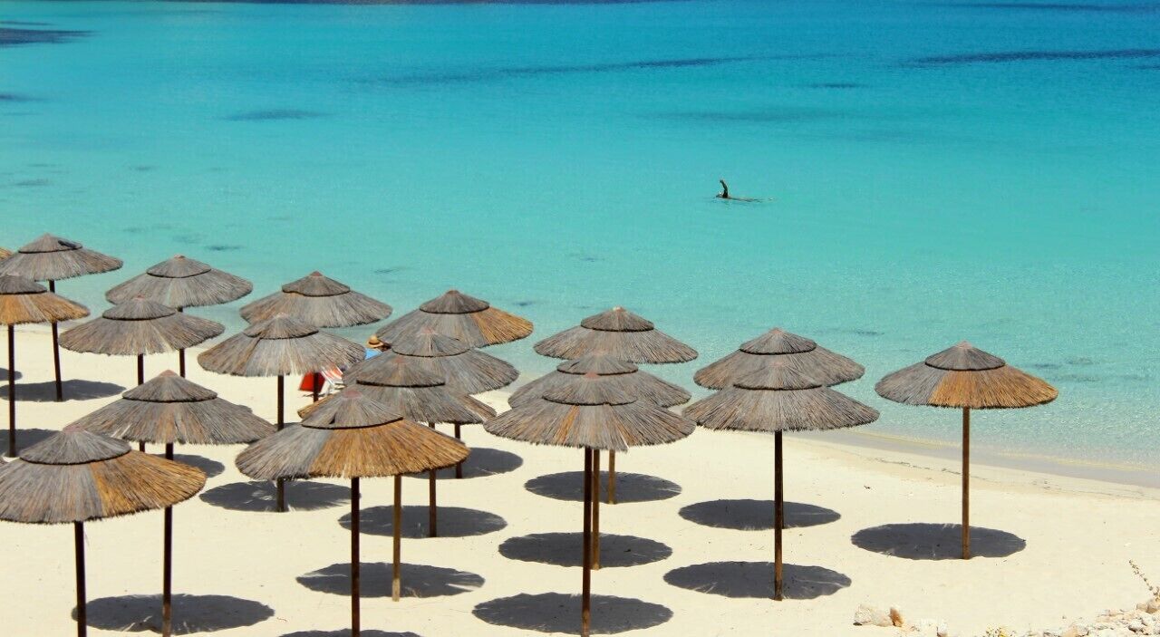 On the beach, white sand, sun loungers, beach umbrellas
