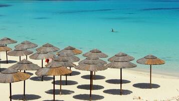 On the beach, white sand, sun loungers, beach umbrellas