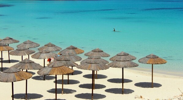 On the beach, white sand, sun-loungers, beach umbrellas