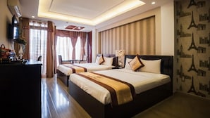 A hotel room with two beds, a desk, a TV, and a view of the cityscape. - Hoang Dung Hotel – Hong Vina (Ho Chi Minh City)