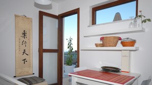A modern kitchen with a white countertop, a red-striped placemat, and a window with a view of the city.