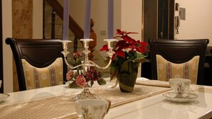 Une table à manger agrémentée d’un vase de fleurs, d’un chandelier et d’une tasse à thé.