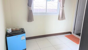A room with a blue refrigerator, a window with curtains, a tiled floor, and a door with a mat. - Sea Beach Koh Larn (Koh Lan)