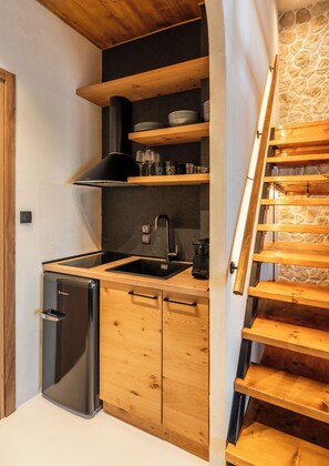 Una cocina con armarios de madera, un refrigerador de acero inoxidable y una estufa empotrada.