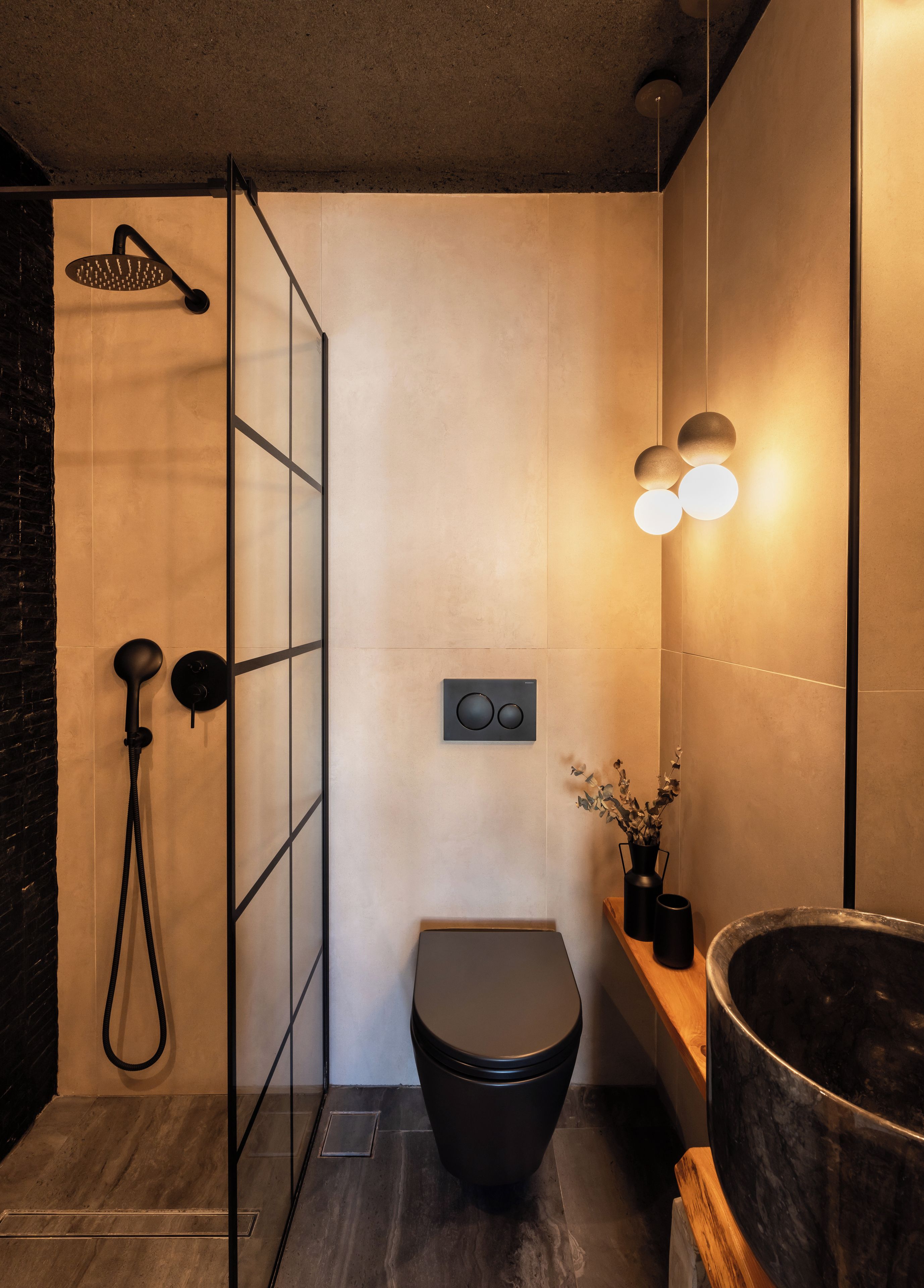 Un baño moderno con ducha, inodoro y lavamanos de gran tamaño.