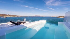 An infinity pool with a clear view of the sea and distant land. - Captain Zeppos (Milos)