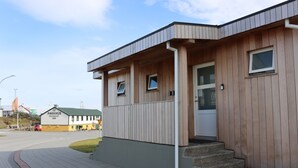 Een gebouw met een houten gevel en een bord waarop 