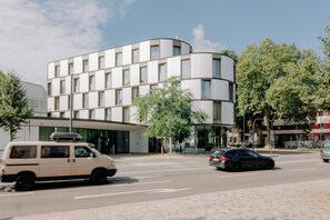 Un bâtiment moderne doté d’une façade incurvée, de grandes fenêtres et d’un toit plat.