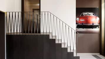 Stunning staircase with a sleek metal railing leads to an upper level, complemented by a striking framed art piece.