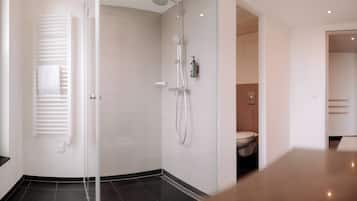 A modern bathroom with a glass shower enclosure, a toilet, and a sink.