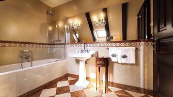 A bathroom with a bathtub, shower, sink, and vanity.