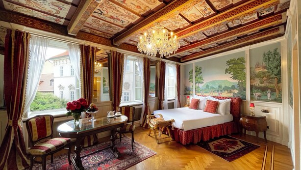 A luxurious bedroom with a large bed, ornate ceiling, and a scenic mural. - Alchymist Prague Castle Suites Hotel (Prague)