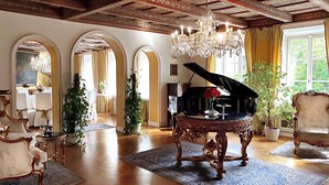 A grand room with a grand piano, ornate furniture, and a chandelier. - Alchymist Prague Castle Suites Hotel (Prague)