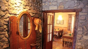 A rustic stone wall with a woven basket and a mirror. - Hotel Rural Irigoienea (Urdax)