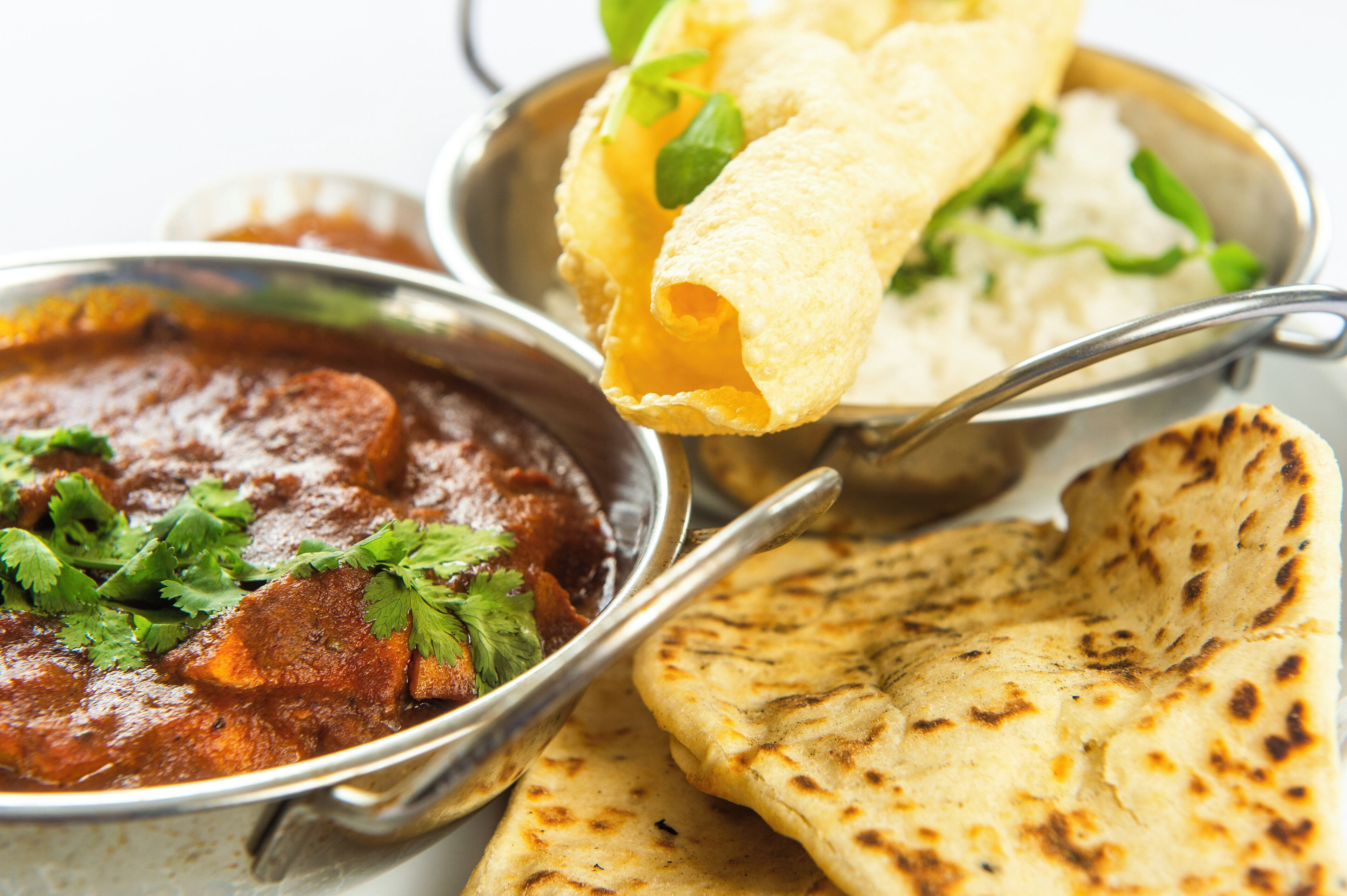 Un plato con curry, pan naan y arroz.