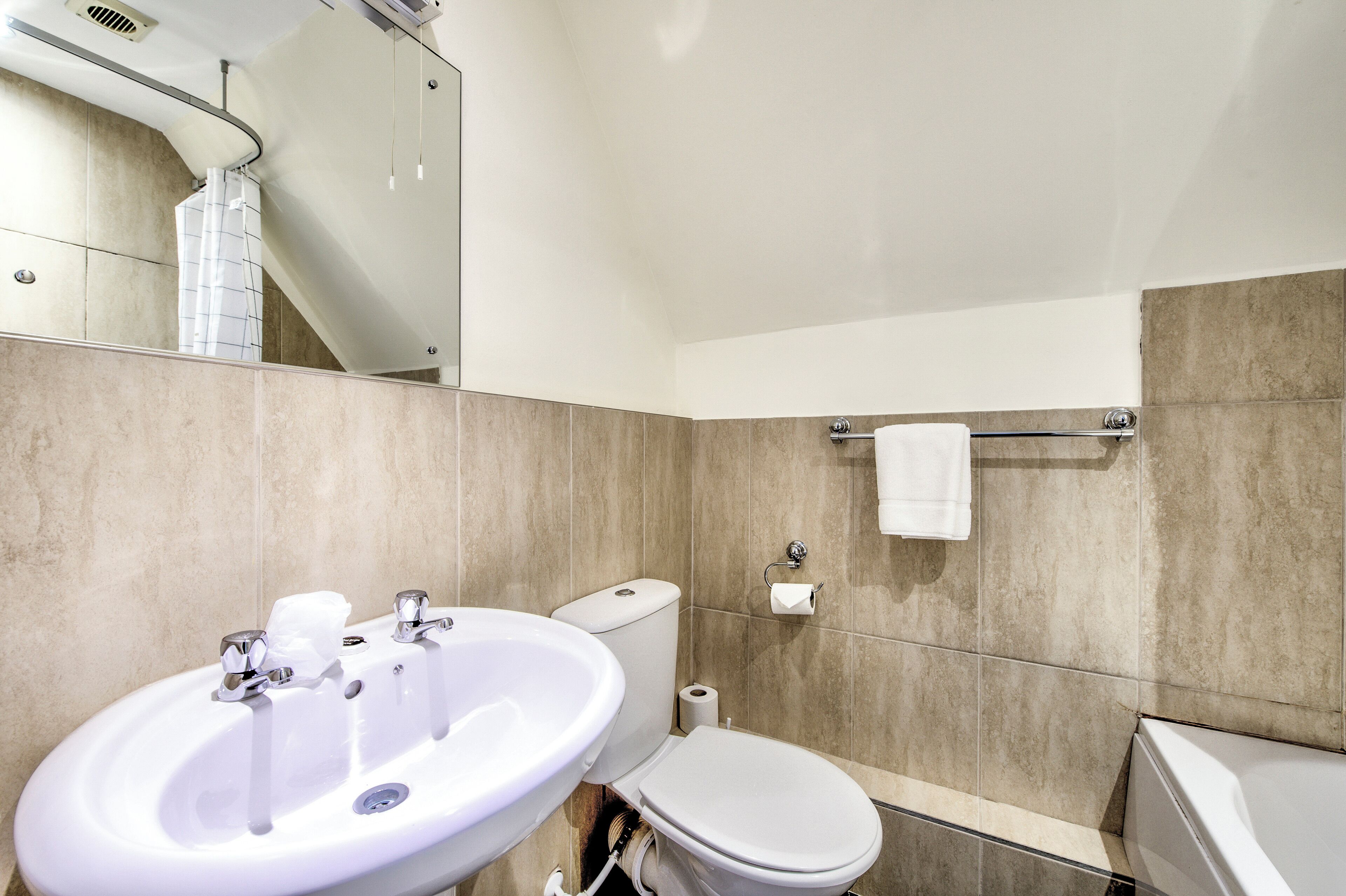 Un baño moderno con lavamanos, inodoro y bañera.