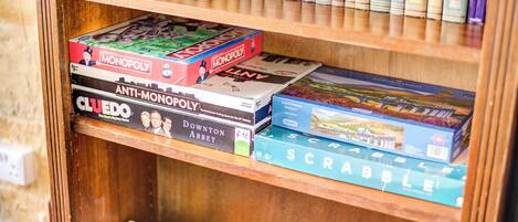 A wooden bookshelf with various board games and books.