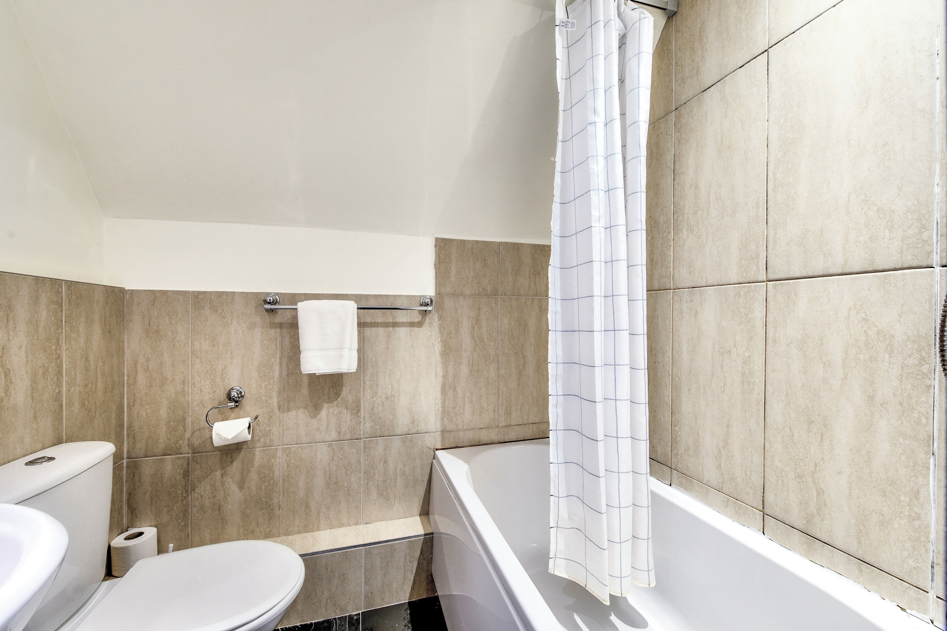 Un baño con inodoro, lavamanos y bañera.