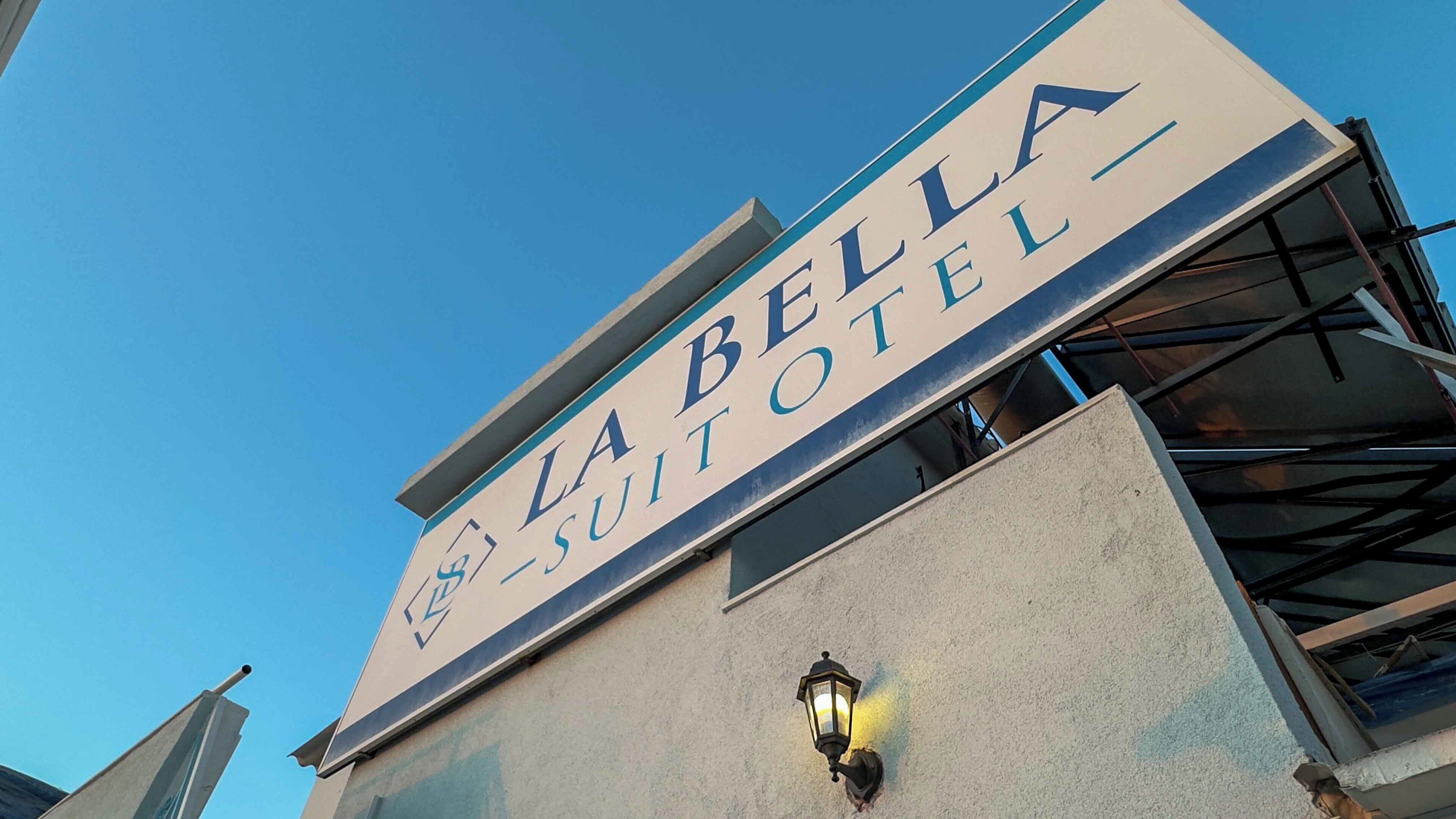 A sign for La Bella Suitotel with a clear sky in the background.