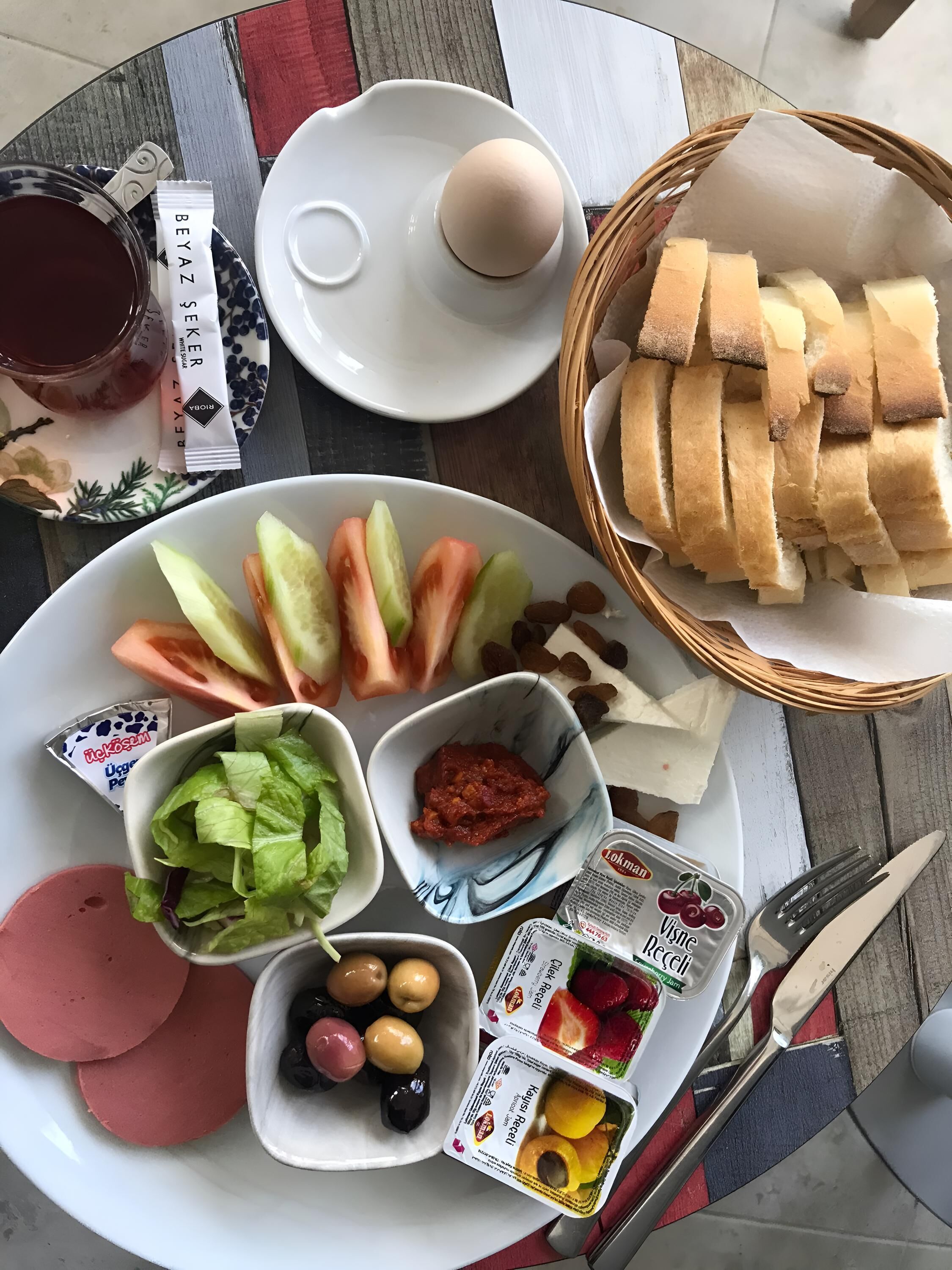 Ein Tisch mit einer Auswahl an Speisen, darunter Brot, Eier, Gemüse und Beilagen.