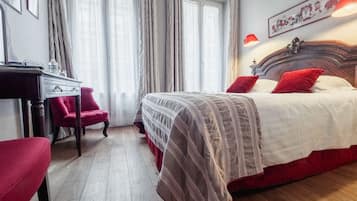 Una habitación de hotel con una cama grande, un escritorio y una silla.