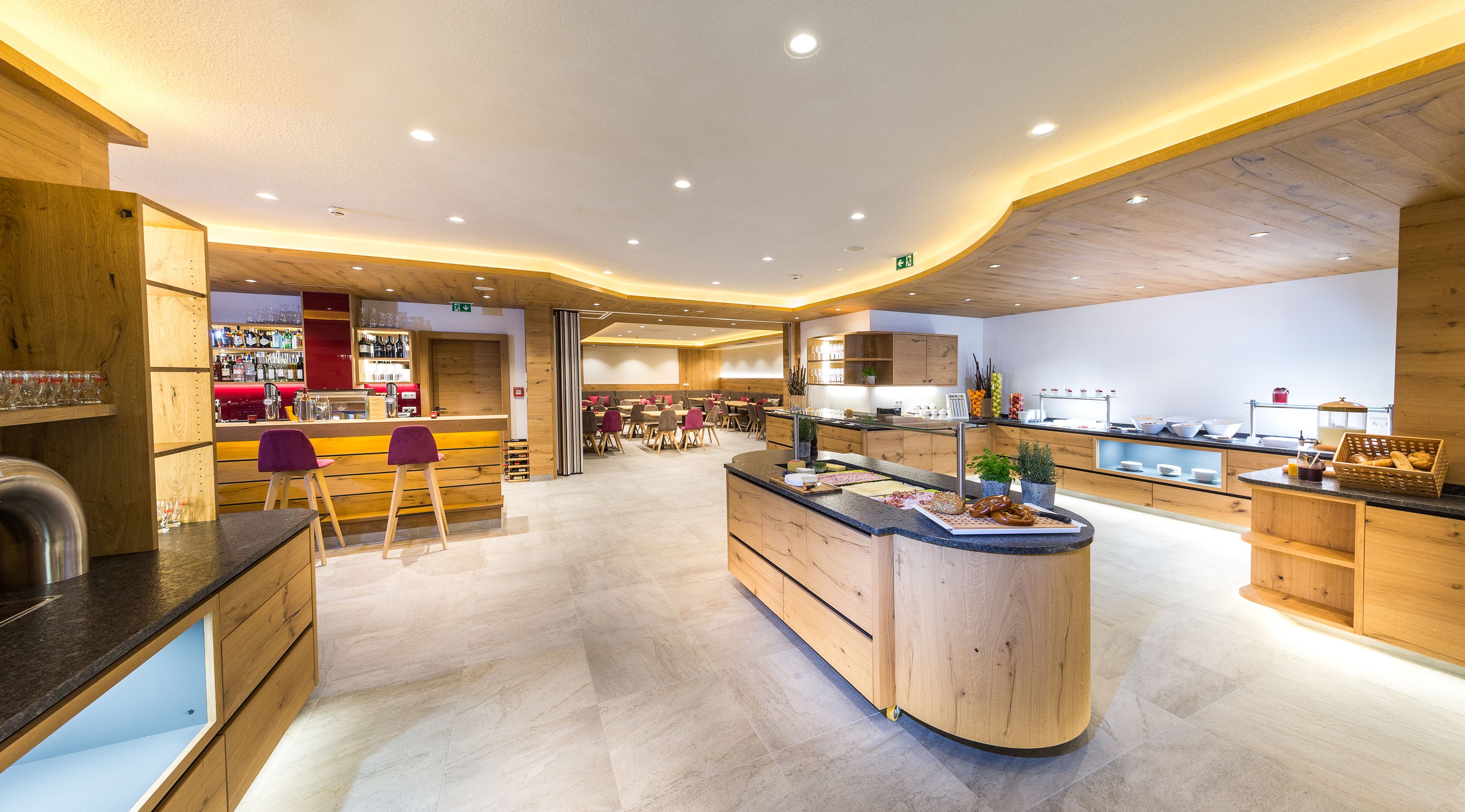 Een modern restaurant met een bar in het midden, houten details en een informele eetruimte.