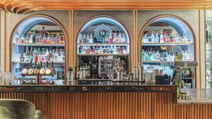 A bar with multiple shelves of liquor bottles, a coffee machine, and a decorative frog statue. - Diamond Suites by Reykjavik Keflavik Airport (Reykjanesbær)