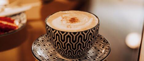 Una taza de café con un platillo estampado sobre una mesa.