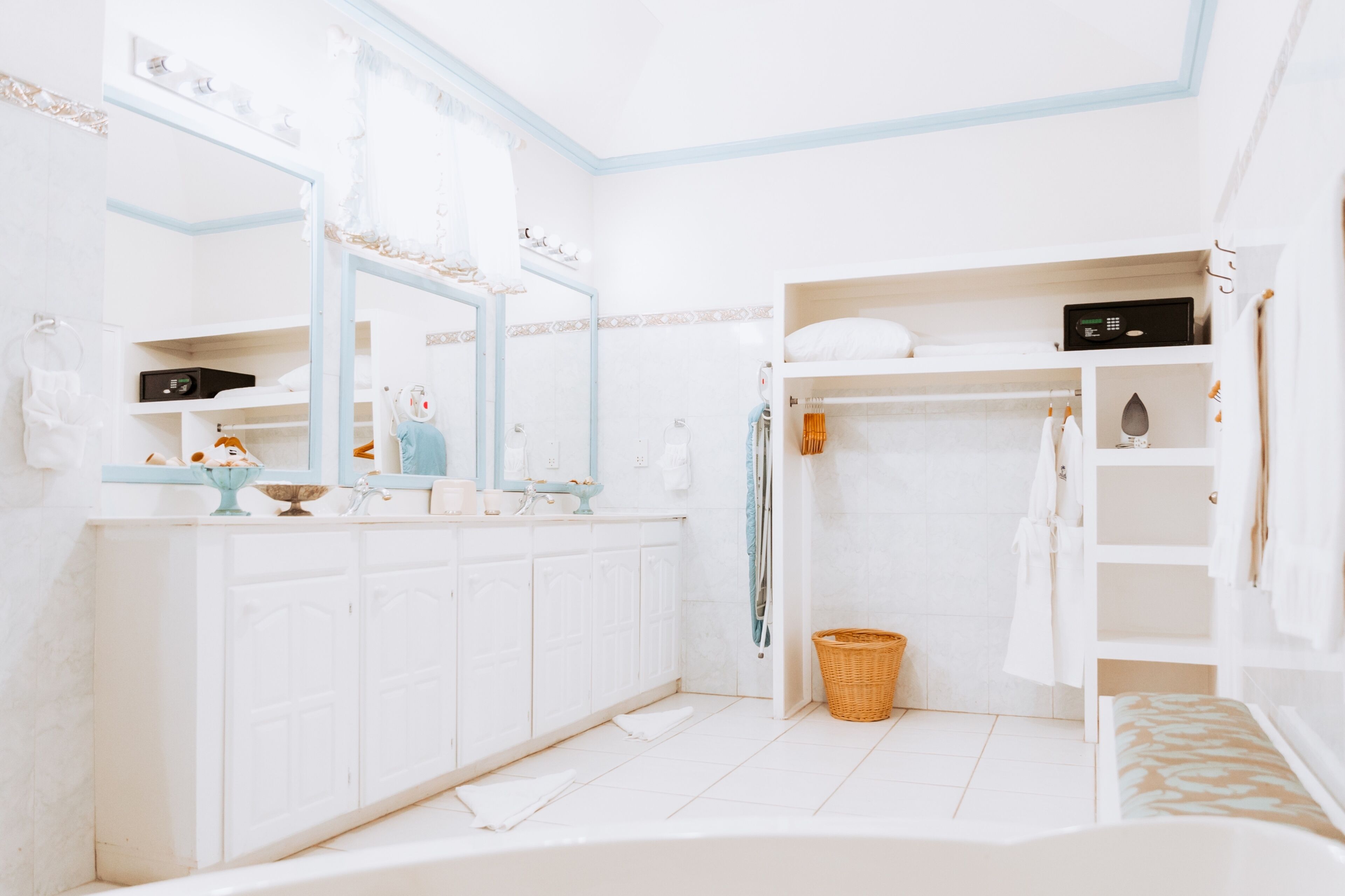 A modern bathroom with a white vanity, a large mirror, a bathtub, and a shower area.