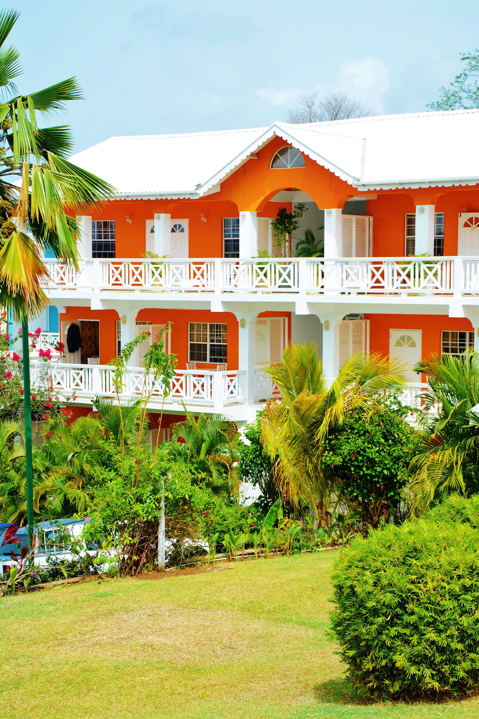 A two-story building with a white balcony and orange walls.