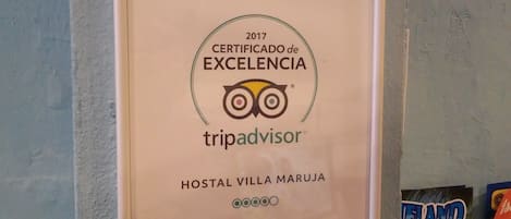 A framed TripAdvisor excellence certificate for Hostal Villa Maruja.