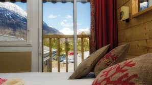 A bedroom with a large window overlooking a snowy mountain and a parking area. - Club Vacances Bleues Les Alpes d'Azur (La Salle-les-Alpes)