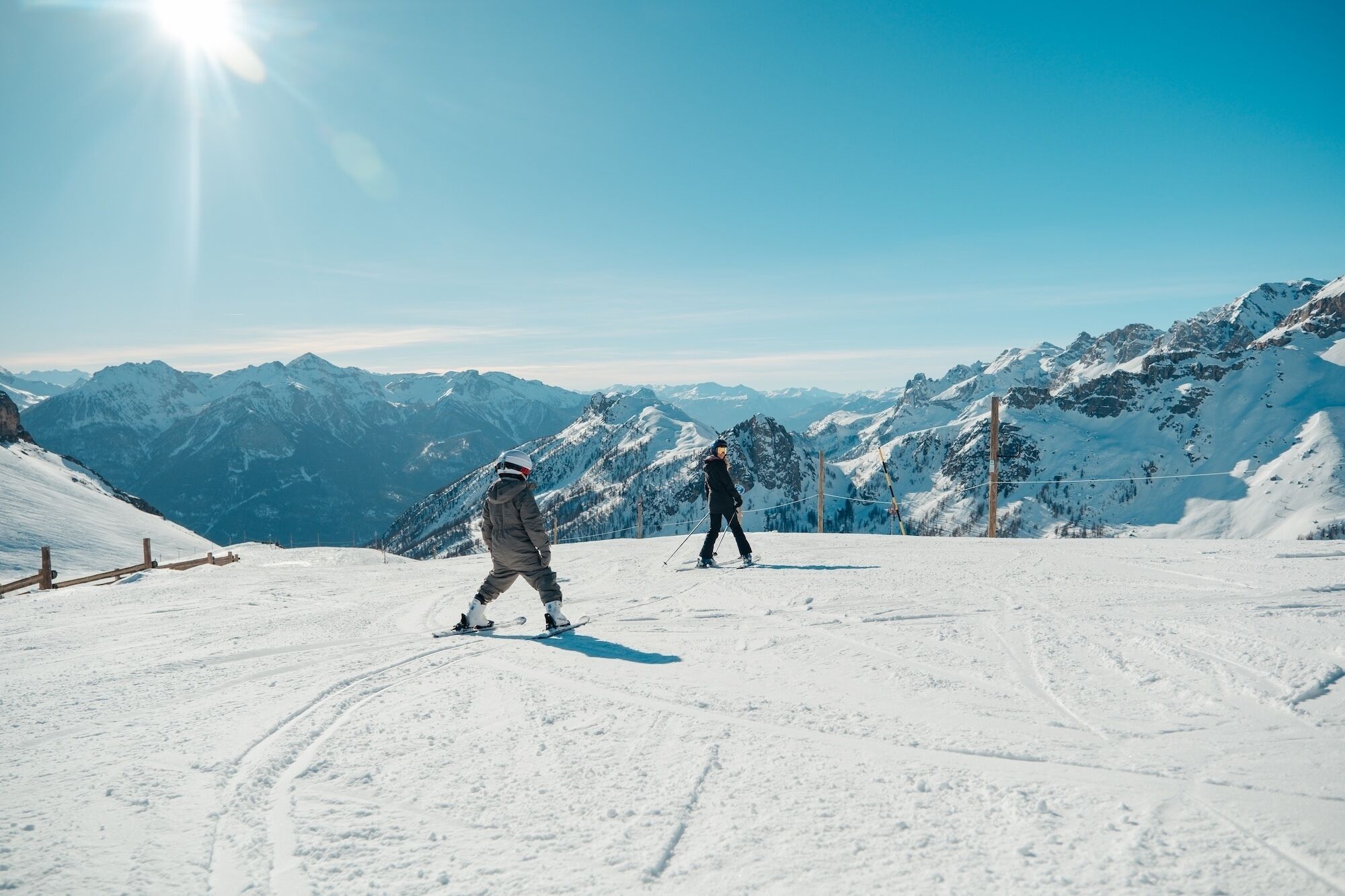 A snowy mountain landscape with skiers.
