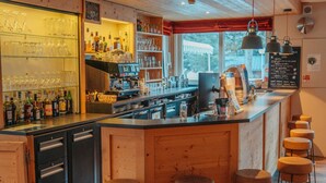 A bar area with stools, a counter, and shelves with bottles. - Club Vacances Bleues Les Alpes d'Azur (La Salle-les-Alpes)