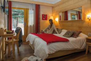 Relax in this inviting bedroom with a large bed, wooden desk, and comfortable seating area.