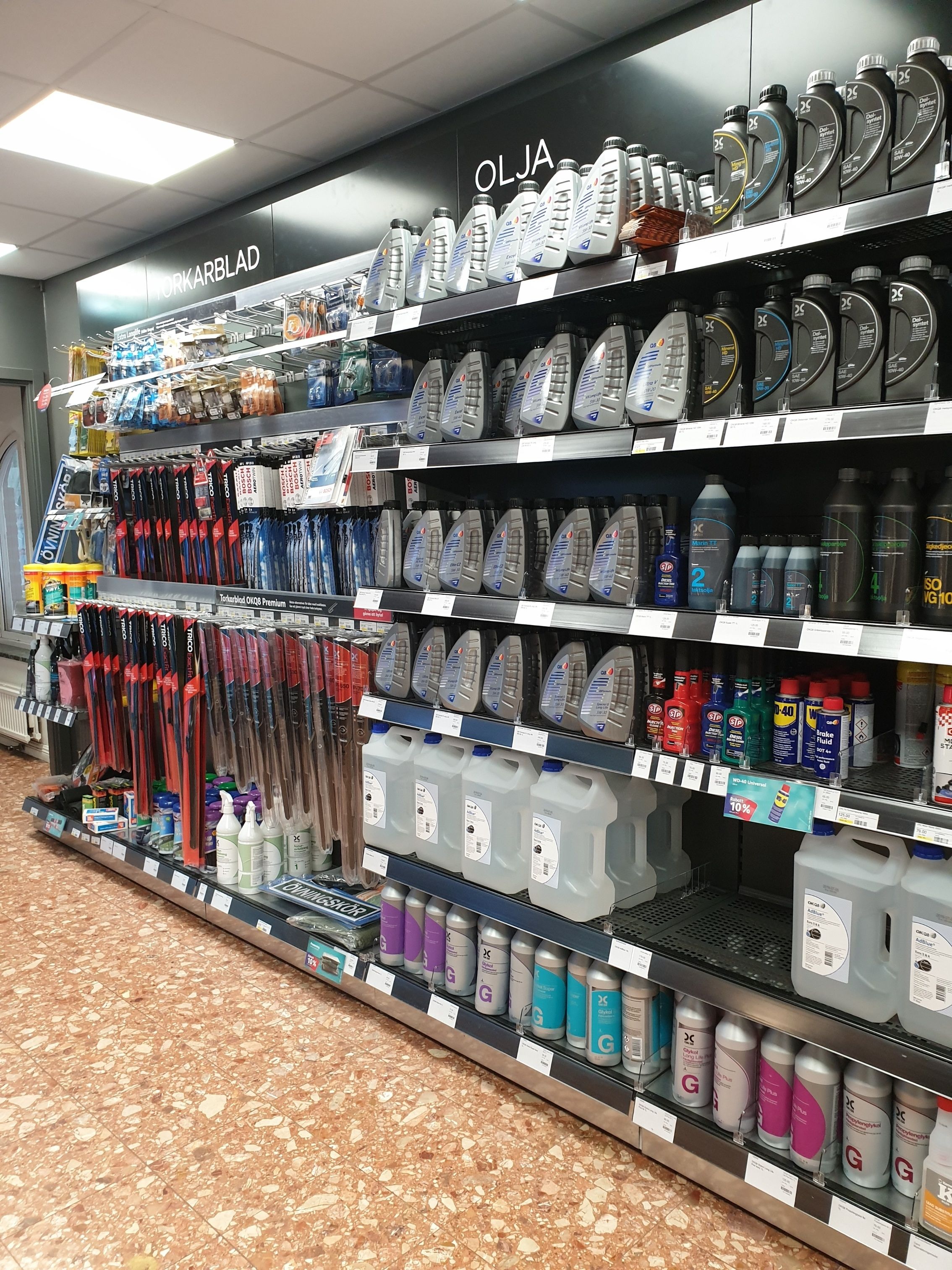 A store aisle with various cleaning products and household items on shelves.