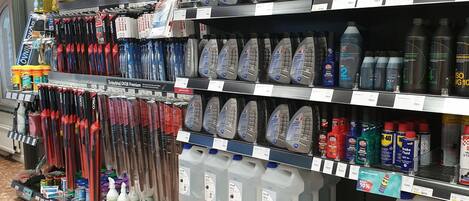 A store aisle with various cleaning products and household items on shelves.