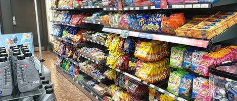 Pasillo de un supermercado con estantes llenos de diferentes snacks y bebidas.