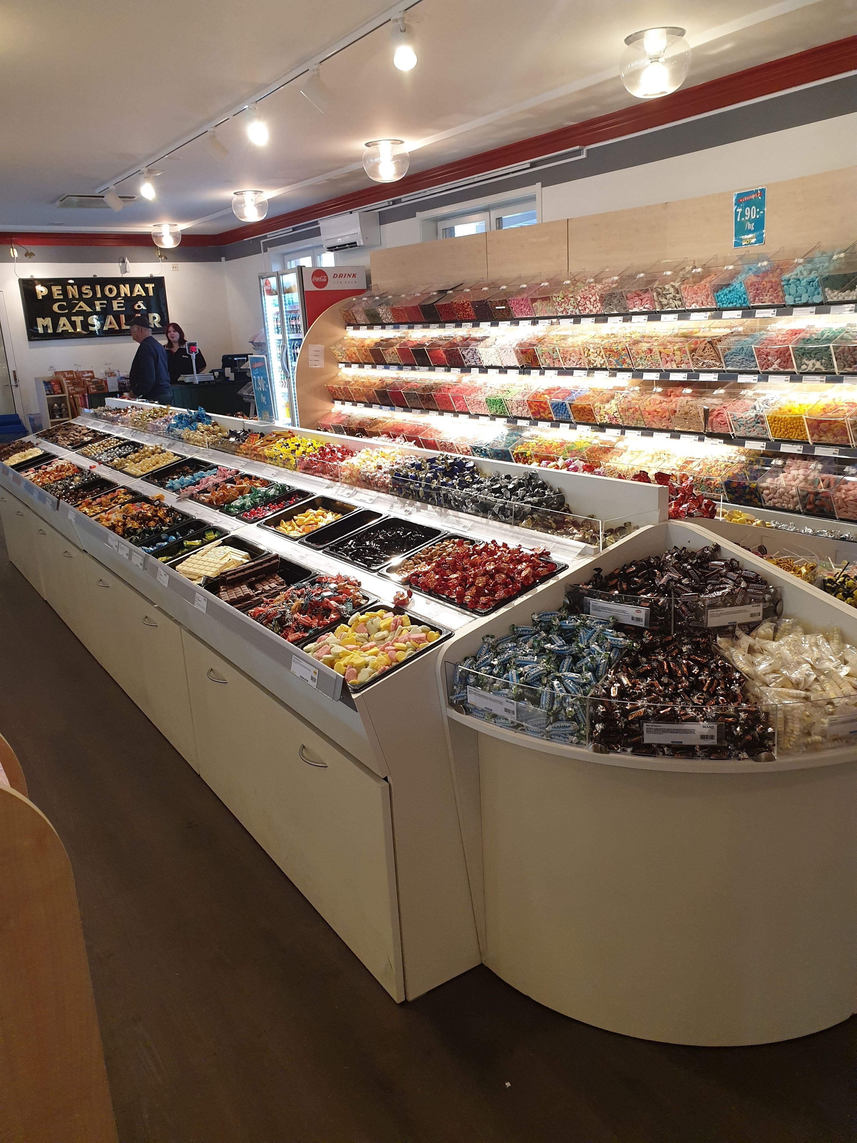 Ett godisbord i en butik med flera fack fyllda med olika sorters godis.