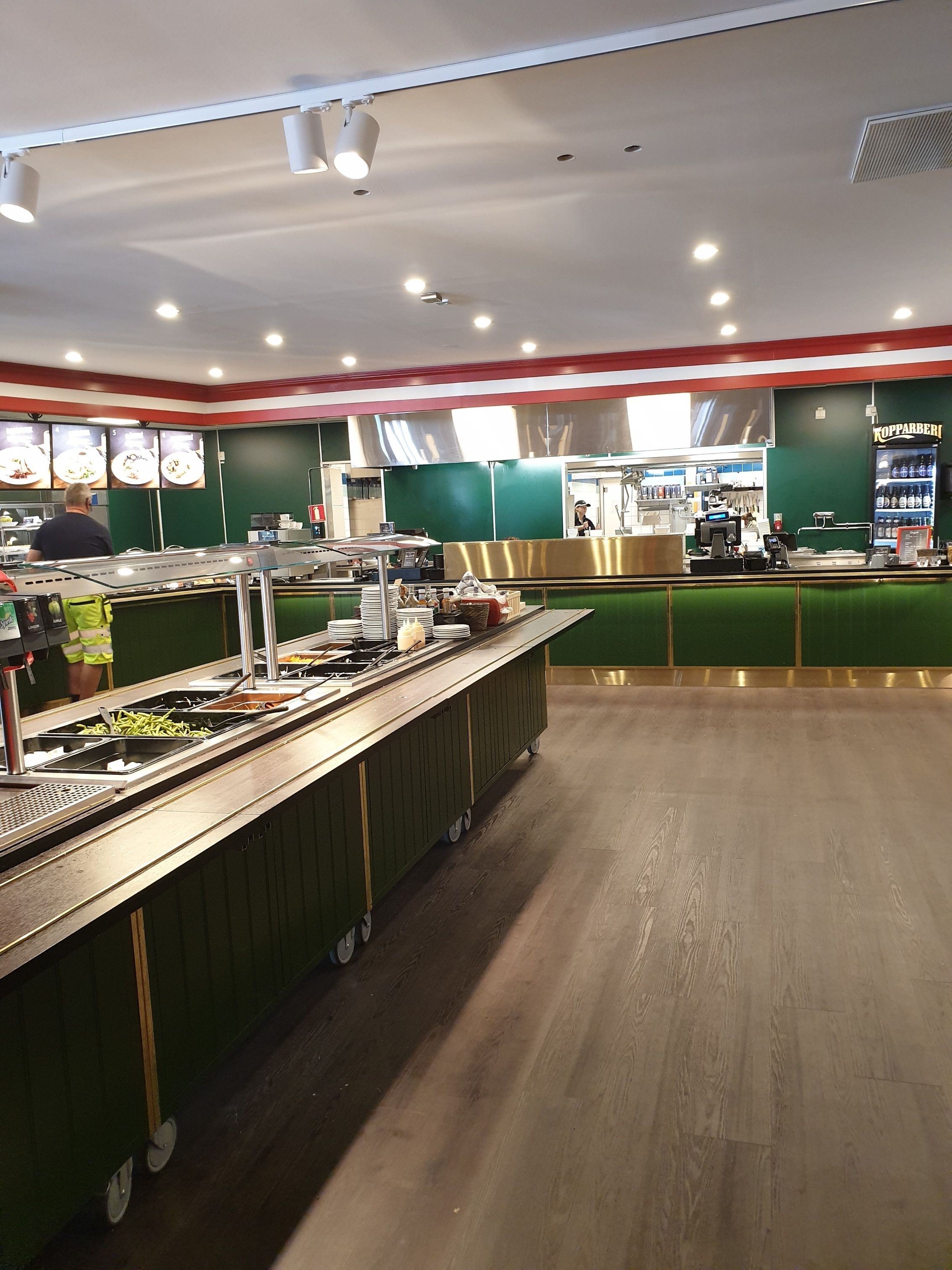 Ein Buffetbereich mit verschiedenen Speisenstationen und einem Getränkeautomaten im Hintergrund.