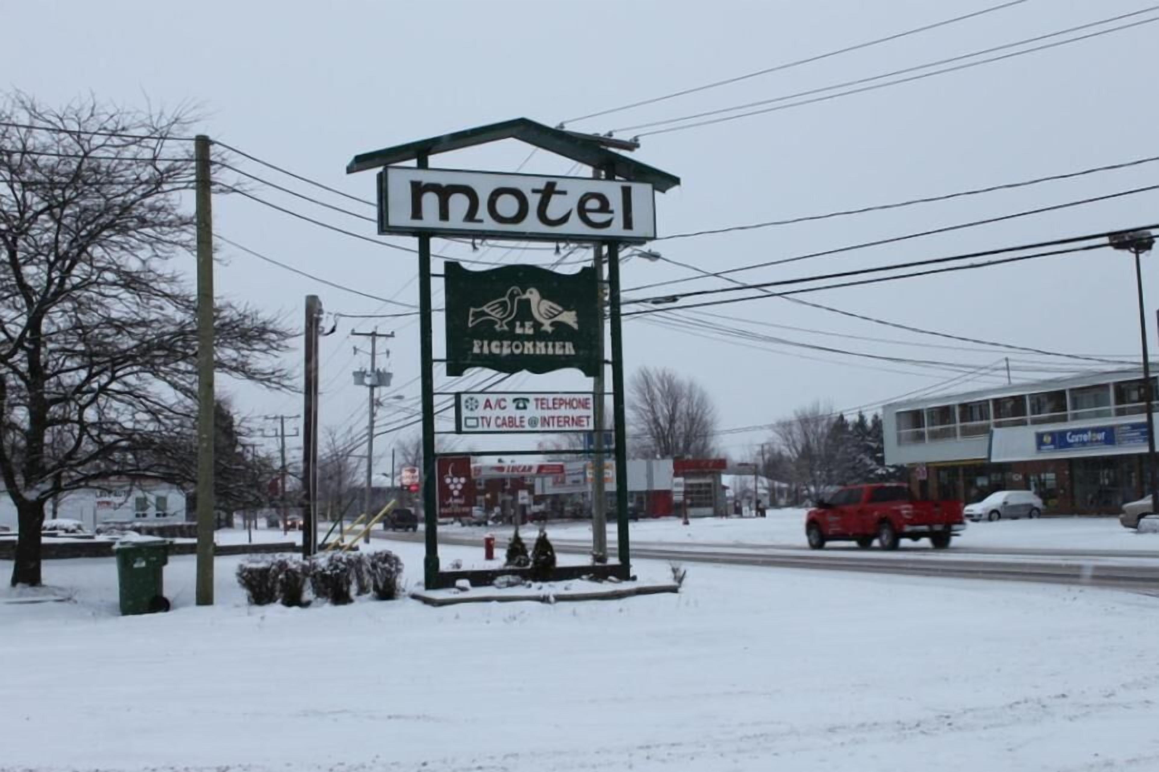 Un panneau indiquant un motel proposant les commodités suivantes : climatisation, téléphone, télévision par câble et accès à Internet.
